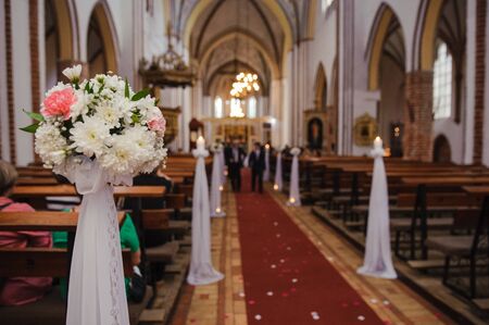 Church sanctuary before a wedding ceremony. Empty chairs for bride and groomの写真素材
