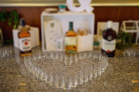 Bottle of cold vodka and wine bottle in bucket with ice and orange juice in jug on table, copy space. Alcohol bottles in ice bucket in restaurant. Wedding partyの写真素材