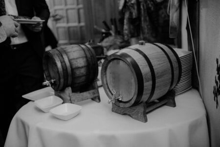 Bottle of cold vodka and wine bottle in bucket with ice and orange juice in jug on table, copy space. Alcohol bottles in ice bucket in restaurant. Wedding partyの写真素材