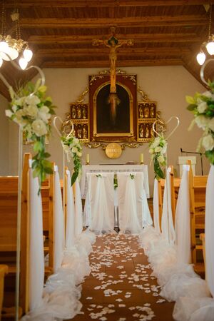 Church sanctuary before a wedding ceremony. Empty chairs for bride and groomの写真素材