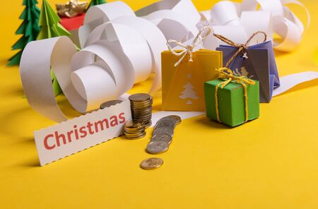 Holiday expenses concept. Long twisted christmas expenses list, presents, gifts, money coins and christmas textの写真素材