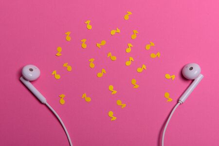 white earphones and white paper notes on orange background. view from aboveの写真素材