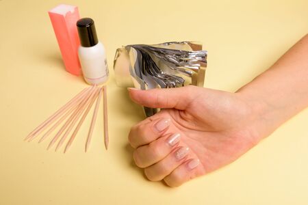 The procedure for removing varnish from nails hybrid nails in progress. Gel nail polish remover foils on woman's handsの写真素材