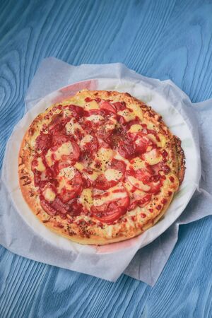Homemade pepperoni pizza on the table. Tomato, cheese and ham main ingredients.の写真素材