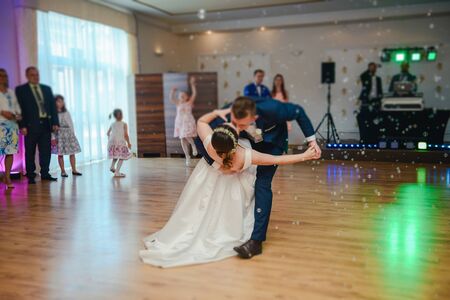 Bride and groom dancing the first dance at their wedding day. Guest on the dancefloorの写真素材