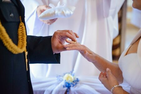 the bride and groom during the wedding ceremony put wedding rings on their fingers.の写真素材