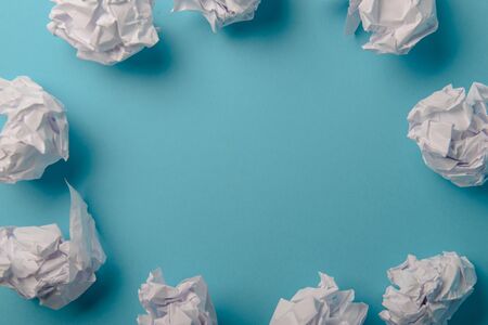 crumpled paper ball isolated on a blue backgroundの写真素材