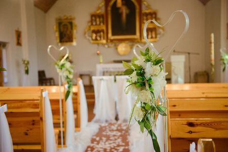 Church sanctuary before a wedding ceremony. Empty chairs for bride and groomの写真素材