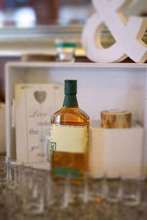 Bottle of cold vodka and wine bottle in bucket with ice and orange juice in jug on table, copy space. Alcohol bottles in ice bucket in restaurant. Wedding partyの写真素材