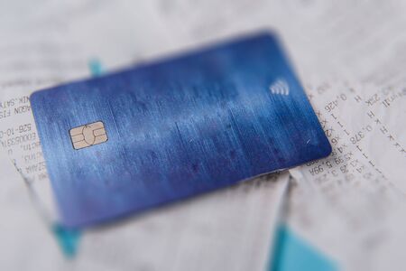 Close-up Of Credit Card On Shopping Receipt On Blue Backgroundの写真素材
