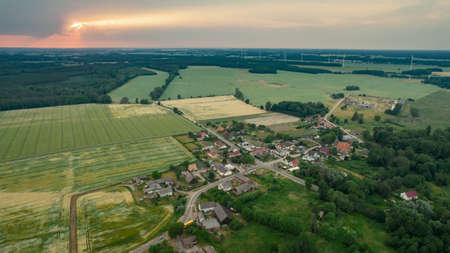 Aerial photo of a typical Polish hosing estate in the mountains towns, taken on a sunny part cloudy day using a drone, showing the housing estate and farmers fieldsの写真素材