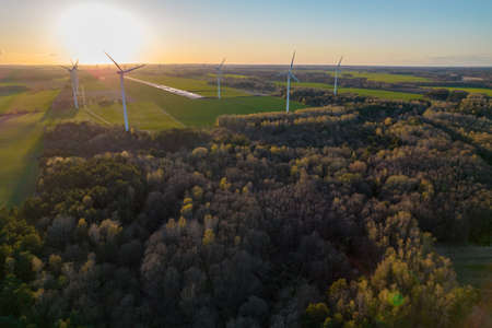 Aerial photo of windmills and blue sea at sunset.の写真素材