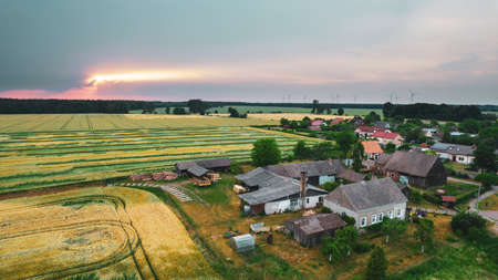 Aerial photo of a typical Polish hosing estate in the mountains towns, taken on a sunny part cloudy day using a drone, showing the housing estate and farmers fieldsの写真素材