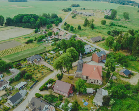 Aerial photo of a typical Polish hosing estate in the mountains towns, taken on a sunny part cloudy day using a drone, showing the housing estate and farmers fieldsの写真素材
