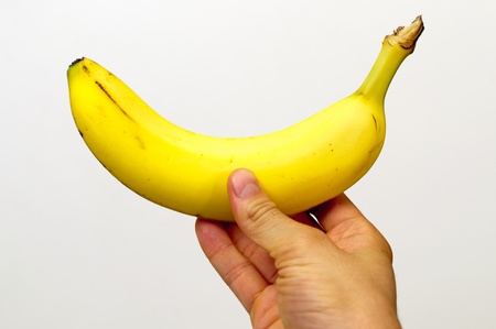 Right hand holding a yellow bananaの写真素材