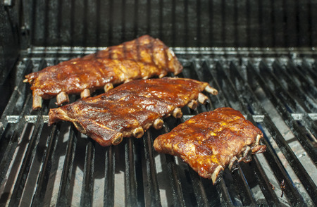 Baby back ribs cooking on the barbecue grillの写真素材
