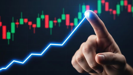 A close-up shot captures a hand's index finger touching a glowing blue upward trend line on a dark digital display. In the background, a stock market candlestick chart with green and red bars represents financial data and market fluctuations. The finger's interaction with the rising line symbolizes concepts like growth, investment success, financial planning, technological advancement in trading, and reaching peak performance or achieving goals. The image creates a dynamic, high-tech feel related to finance and business strategy.の素材