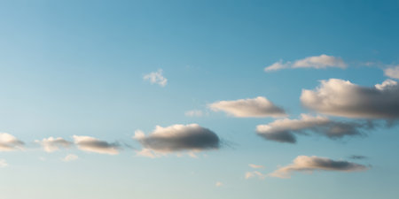 The showcases a minimalist of a clear blue sky adorned with scattered, fluffy white clouds. The clouds vary in size and shape, creating a serene and peaceful atmosphere. The bright blue sky contrasts beautifully with the soft white clouds, evoking a sense of calm and tranquility. The composition is simple yet focusing on the natural beauty of the sky and clouds.の素材