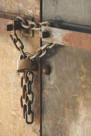 Rusty Chain with Lock on old Metal Double Doors