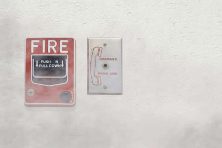 Fire Alarm Notifier and Fireman's Phone Jack on Cement Plaster Wall with Smoke Effect, Security Conceptの写真素材