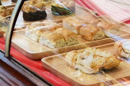 Pastry Shop Vintage Style Glass Display with Selection of Mixed Pastries and Bread Served on Wooden...