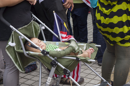 KUALA LUMPUR, MALAYSIA - AUGUST 31: Unidentified baby boy sleeping beside Malaysia national flag during celebration of Independence Day 57th in Merdeka square, Kuala Lumpur, Malaysia on August 31, 2014のeditorial素材
