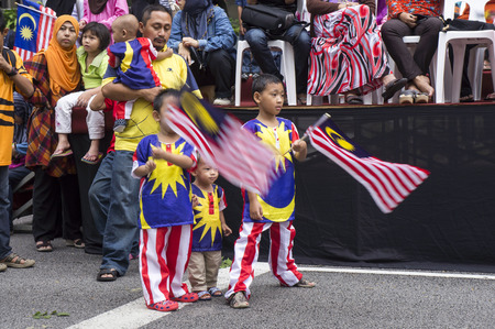 KUALA LUMPUR, MALAYSIA - AUGUST 31: Malaysian kids wearing Malaysia national flag during celebration of Independence day 57th in Merdeka square, Kuala Lumpur, Malaysia on August 31, 2014のeditorial素材