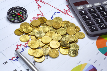 Conceptual of Gold Investment success with calculator, compas, ballpoint and graph on the backgroundの写真素材