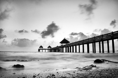 Monochrome low tide at jetty during sunriseの写真素材