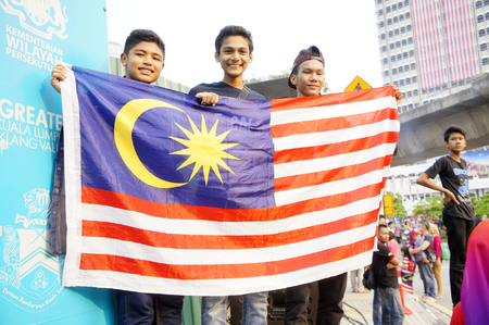 KUALA LUMPUR, MALAYSIA - AUGUST 31: Unidentified Malaysian teenager holding national flag during celebration of Malaysia Independence day 58th in Merdeka square, Kuala Lumpur, Malaysia on August 31, 2015のeditorial素材