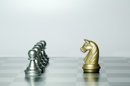 Gold Knight infront of Silver Pawns on chess gameの写真素材