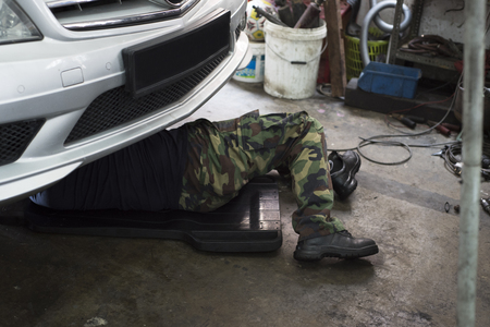 Auto mechanic lying down under the carの写真素材