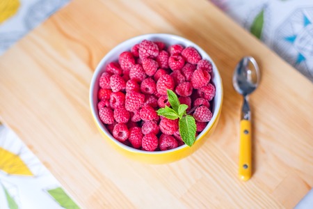 Raspberries in ceramic bowl. Top view. Ripe and tasty raspberries on a wooden background.の写真素材
