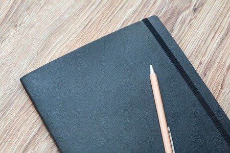 Closed classic planner with pen is on a wooden desk. Nothing extraの写真素材