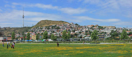 baku city. Azerbaijan. 02.12.2021 year. People with children play in the field. boulevard in early spring.のeditorial素材