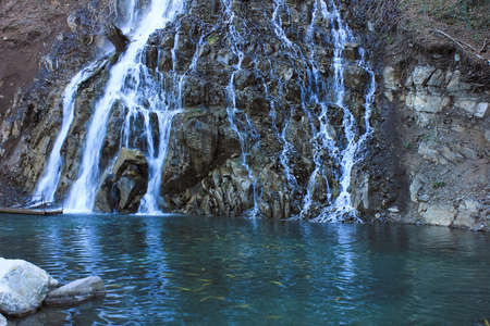 Oguz. Azerbaijan. 03.15.2017 Beautiful waterfall with a lake in the mountains.