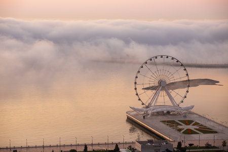 baku city. Azerbaijan. May 16, 2021. Ferris wheel on the boulevard with fog.のeditorial素材