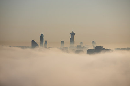 The tops of buildings peek out from the thick fog. baku city. Azerbaijan.のeditorial素材