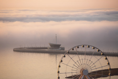 baku city. Azerbaijan. May 16, 2021. Ferris wheel on the boulevard with fog.のeditorial素材