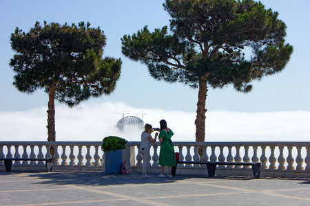 baku city. Azerbaijan. 05.16.2021. The girls take pictures from the mountain park of the fog that covered the city.のeditorial素材