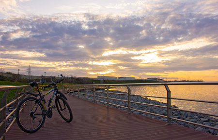 Baku. Azerbaijan. 03.23.2020. Bicycle on the bridge by the lake at sunset. Koroglu metro station.のeditorial素材