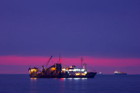 Baku. Azerbaijan. 12.29.2021 Light reflects off the ship on the water. At sunrise.のeditorial素材