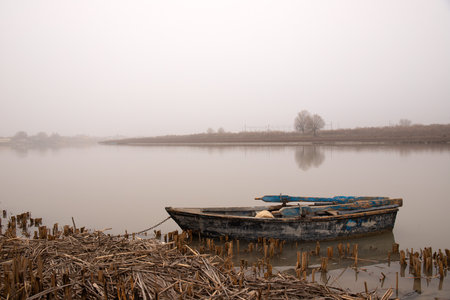 The city of Neftekala, Azerbaijan. 01.28.2021. A wooden boat is moored on the banks of the Kura River.のeditorial素材