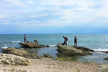 Baku, Azerbaijan, 09.01.2021. Fishermen on the rocks catch fish in the Caspian Sea.のeditorial素材