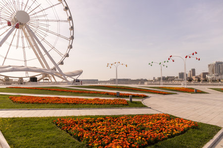 Baku. Azerbaijan. 04.26.2021. Orange flowers on the boulevard near the Ferris wheel.のeditorial素材