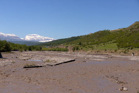 A muddy river flowing from the mountains down the canyon.