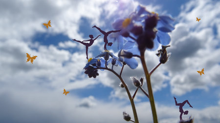 Young girls silhouette taking exercise on a background of blue Forget me not flowers Myosotis sylvatica) and cloudy sky. Photo combined with drawingの写真素材