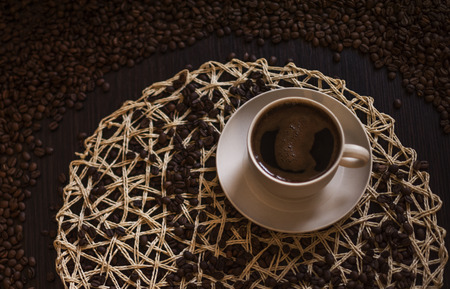 Hot Coffee cup with Coffee beans on the wooden tableの写真素材