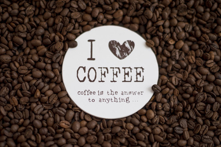 Roasted coffee beans on table with sign I love coffee. Coffee background. Coffee addiction. Coffee is the answer to anything.の写真素材