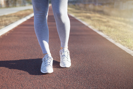 Young fitness woman runner athlete running in city. Woman fitness sunrise jog workout. Healthy lifestyle concept.の写真素材